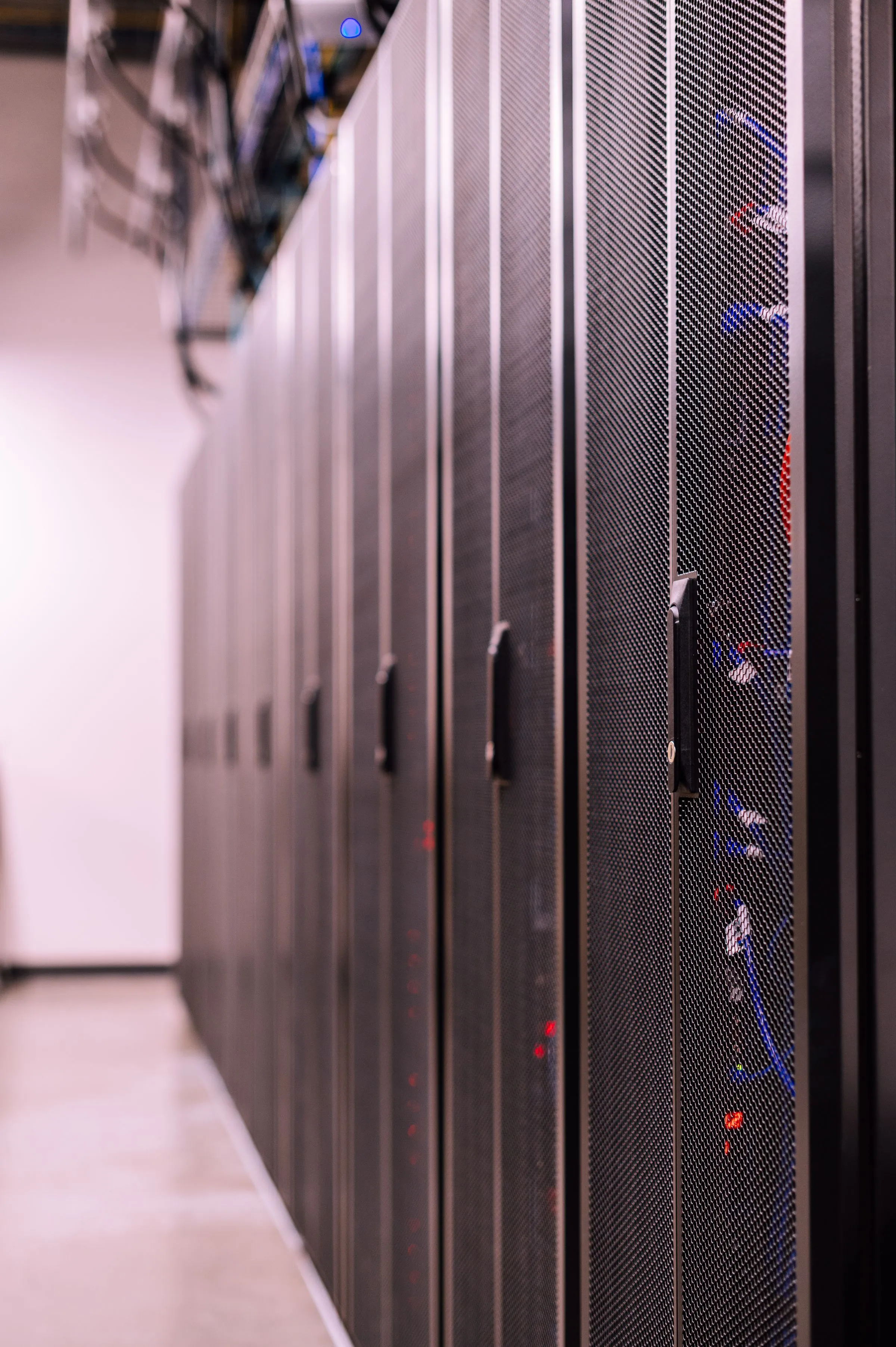 Pasillo de racks de servidores en un centro de datos, iluminación cálida y uniforme