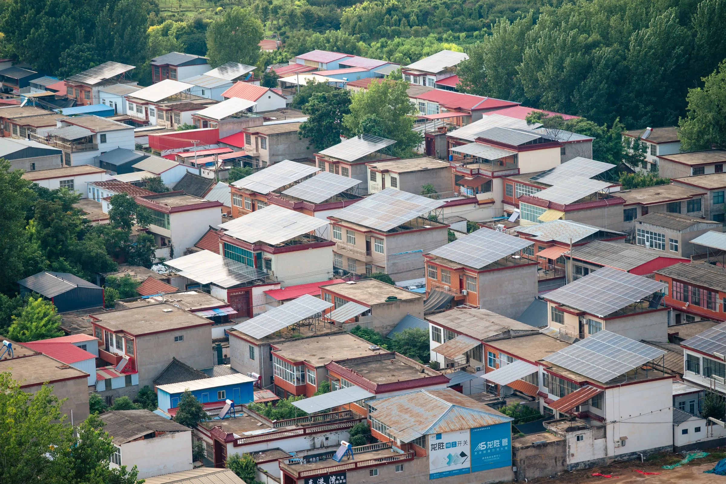Vista aérea de un barrio residencial con paneles solares comunitarios instalados en los techos, Colombia